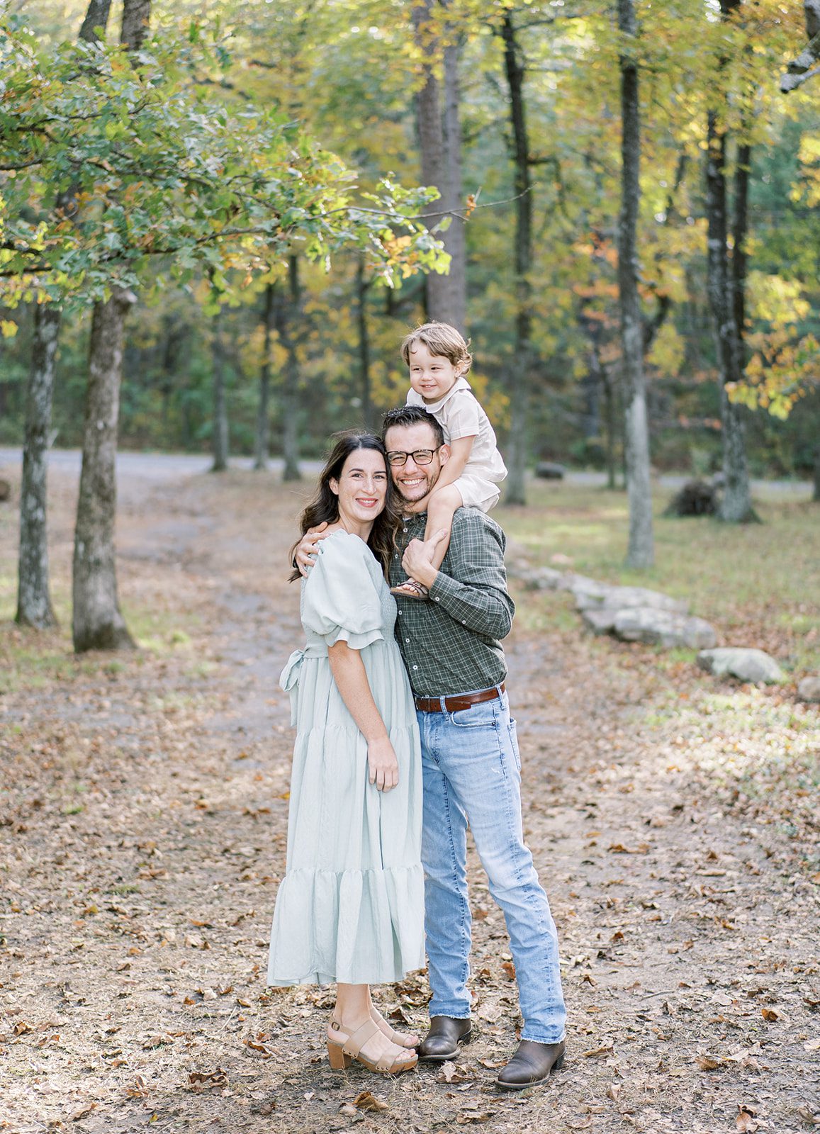 A family smiles with fallen autumn leaves at Brow Park in Mentone, Alabama