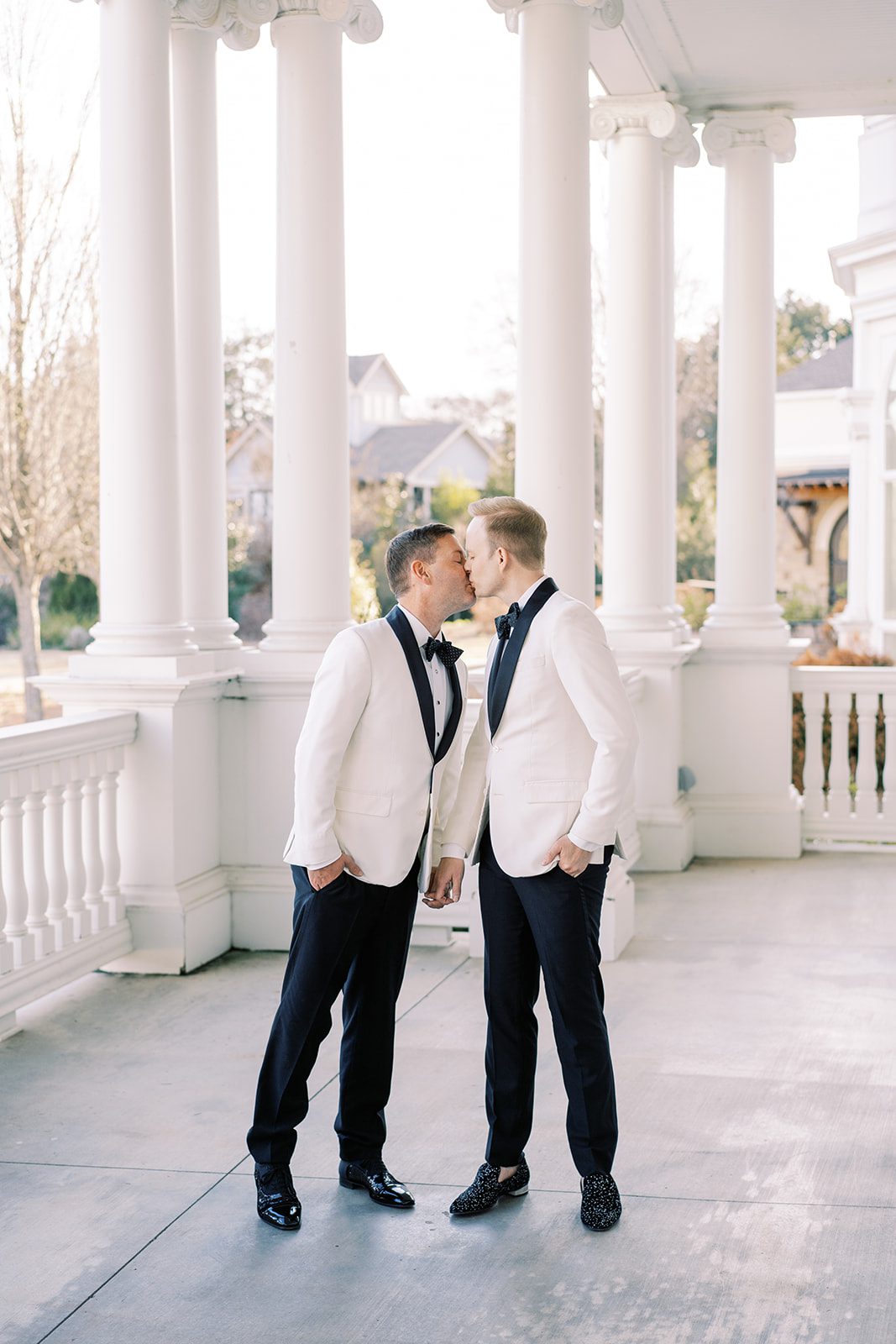 The grooms kiss on the veranda at Huntsville Botanical Gardens in Huntsville, Alabama