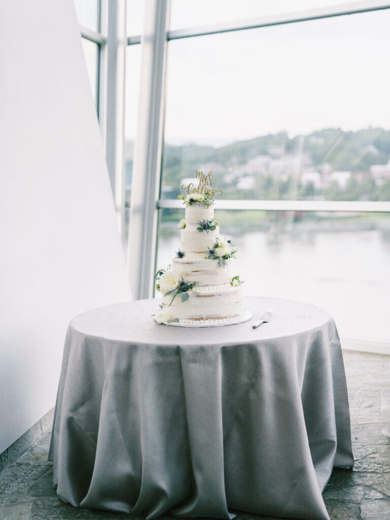 Wedding cake in front of the the Tennessee river view at the Hunter Museum of American Art, a Chattanooga wedding venue, by Kelsey Dawn Photography