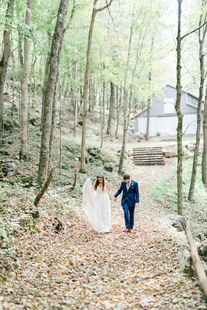 Bride and groom walk through the crunchy, fall leaves at Oakleaf Cottage, a Chattanooga wedding venue, by Kelsey Dawn Photography