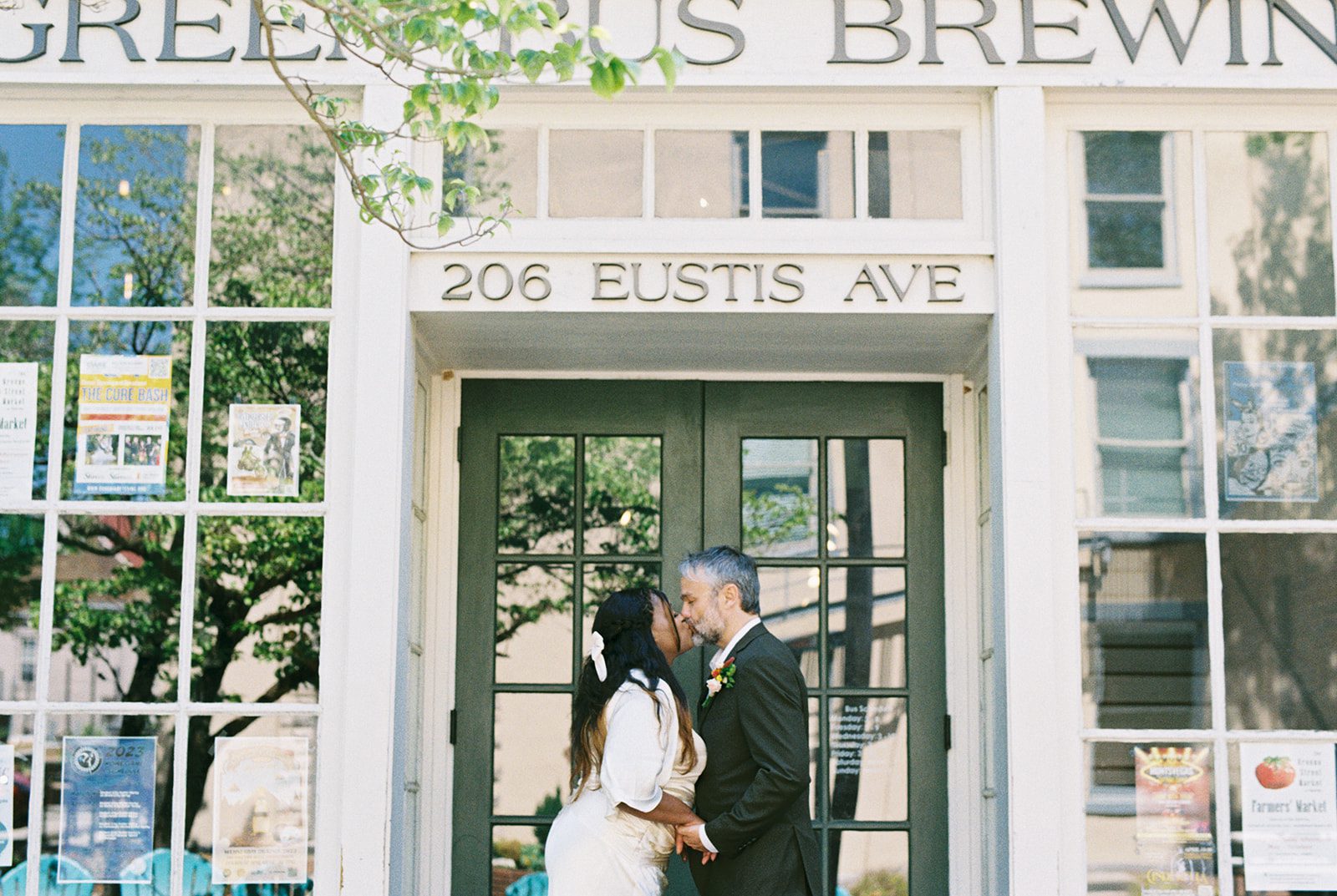 A bride and groom stand in front of Green Bus Brewing in Huntsville, Alabama