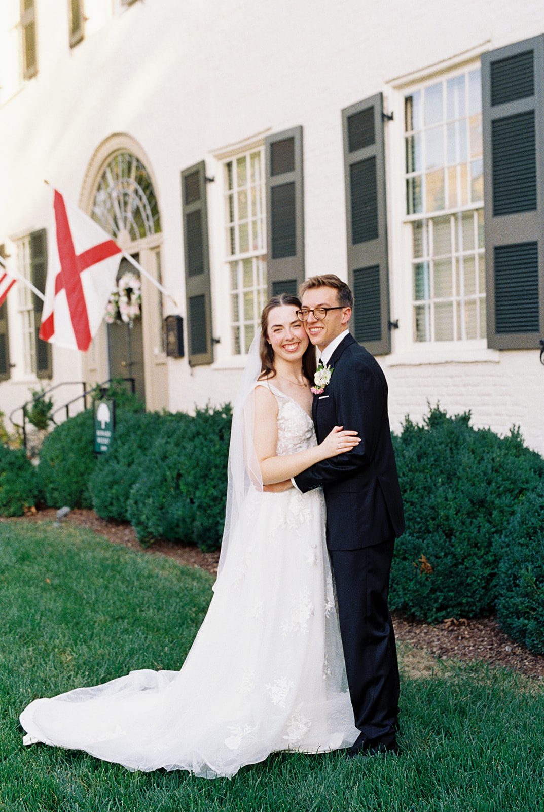 Bride and groom smile at the camera in front of the Weeden House in Huntsville Alabama